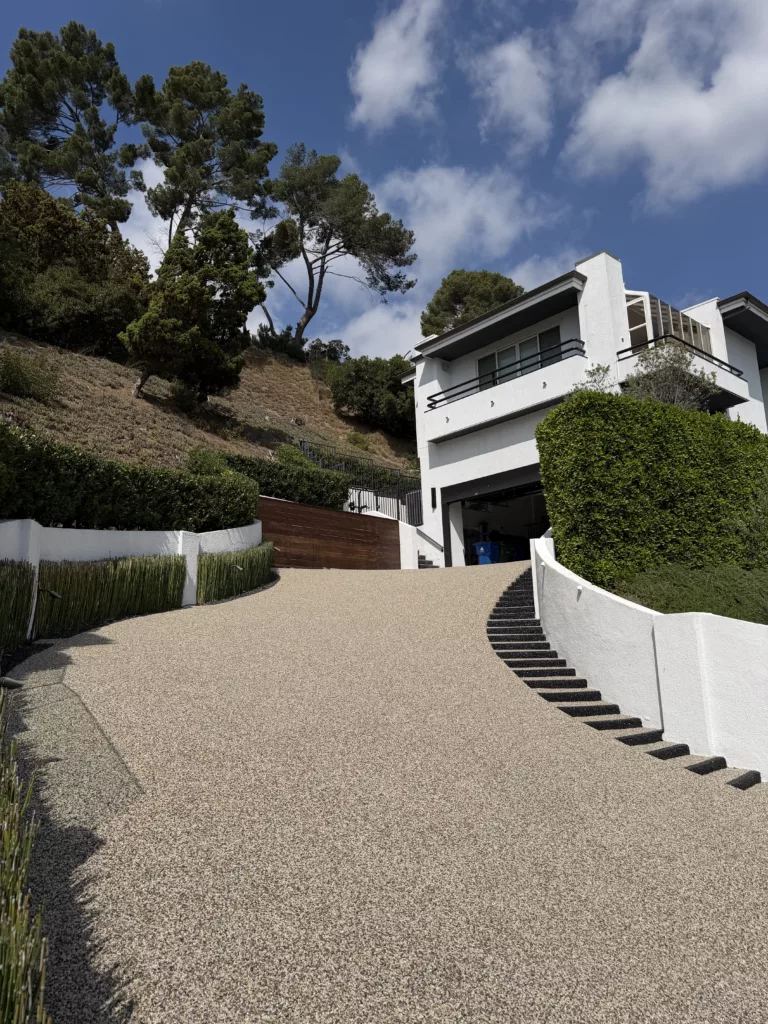 driveway_resurfacing_with_decorative_pebble_epoxy_stonecarpetpros-10-01-2025-2 Close-up of pebble epoxy driveway surface highlighting slip-resistant natural river stones bonded with UV-stable epoxy.