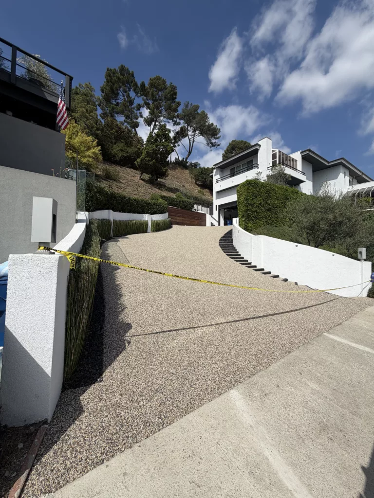 driveway_resurfacing_with_decorative_pebble_epoxy_stonecarpetpros-10-01-2025-3 Wide view of completed pebble epoxy driveway overlay, enhancing curb appeal with durable stone carpet flooring.